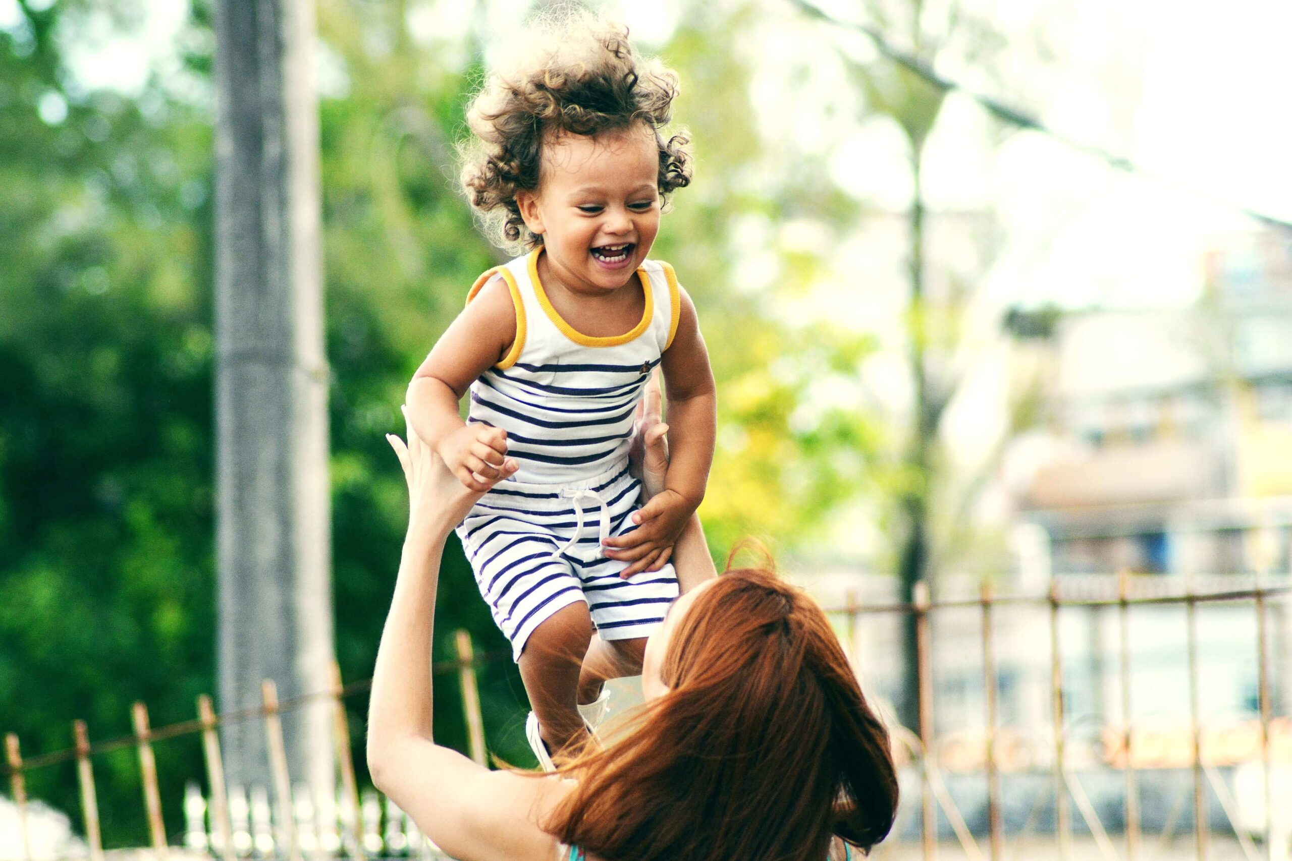 a woman holding a small child in the air